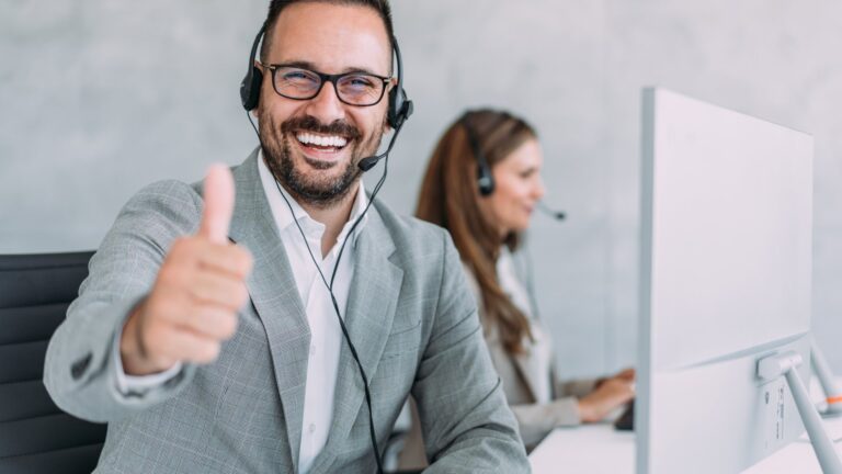 News Zufriedener Support-Mitarbeiter mit Headset zeigt Daumen hoch